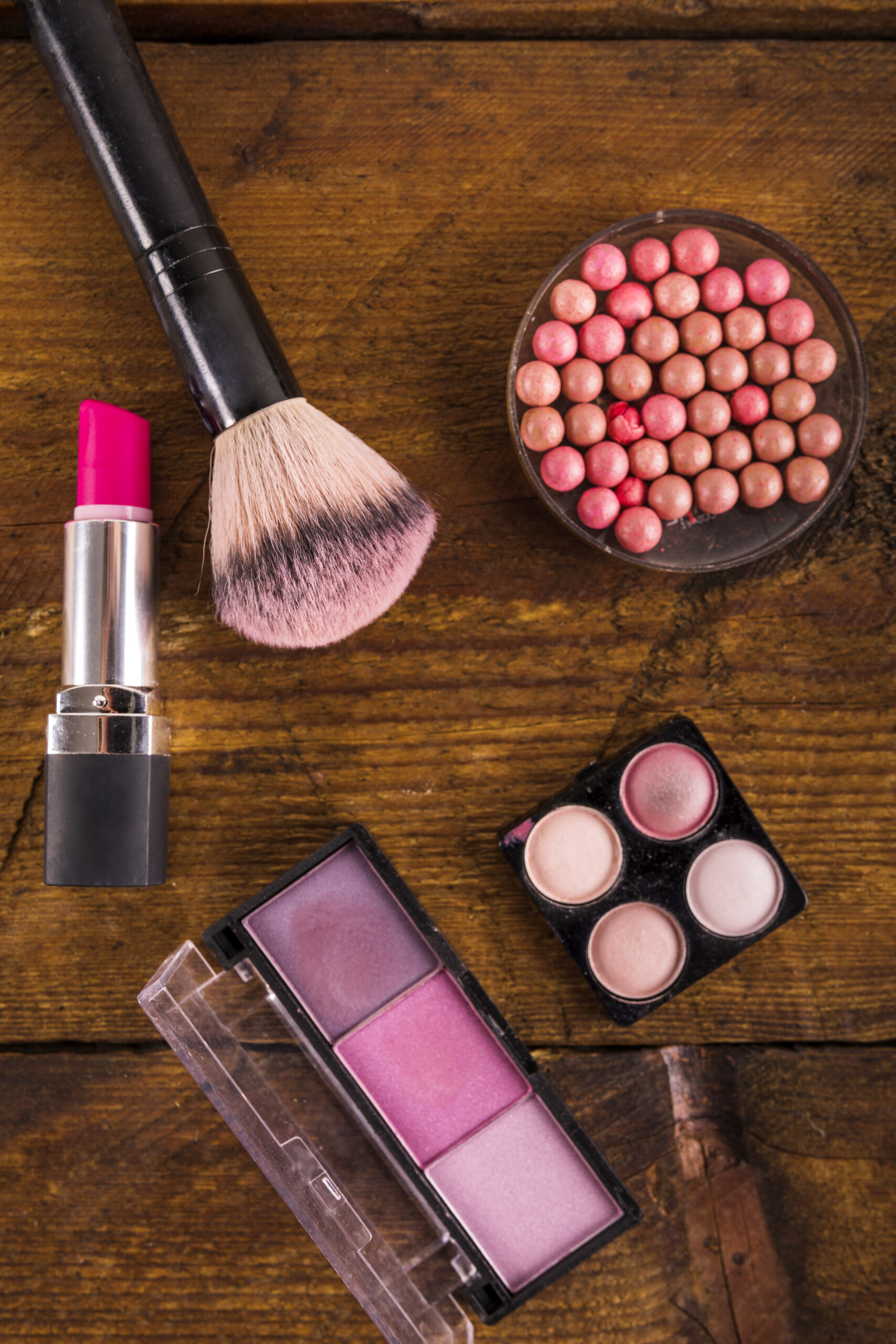 high-angle-view-cosmetic-products-with-brush-wooden-surface